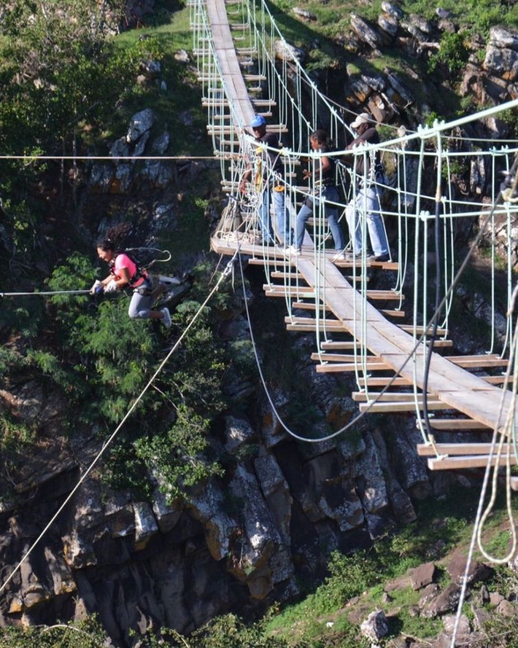 woman jumping from RodrigAventure suspension bridge